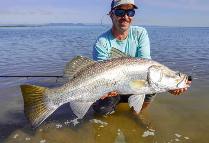 Angler holding large barramundi caught using Fishlogica fishing gear